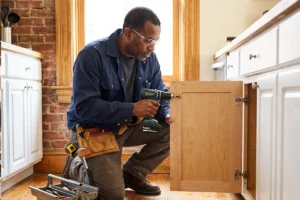 handyman fixing a kitchen cabinet